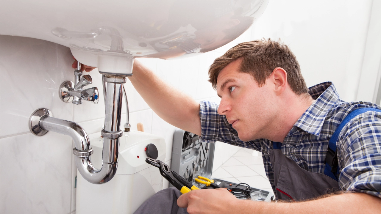 Handwerker fixiert ein Waschbecken im Badezimmer