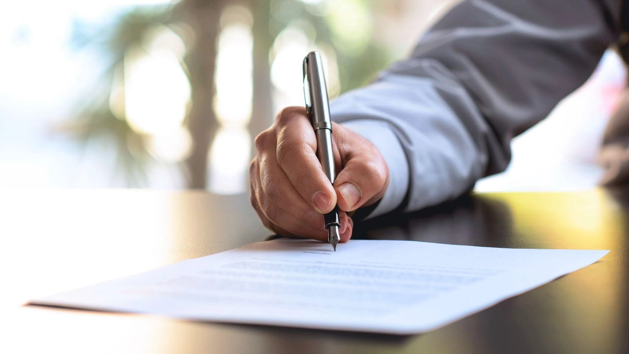 Person unterschreibt ein Dokument