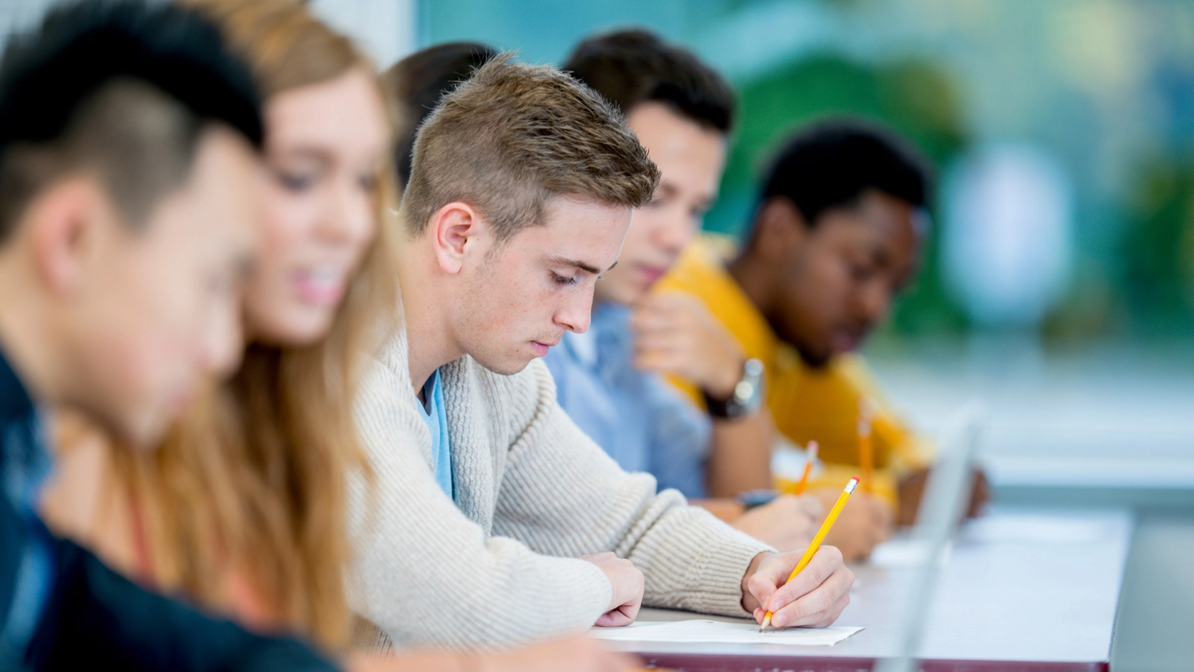 Ein Student macht sich Notizen während eines Seminars.