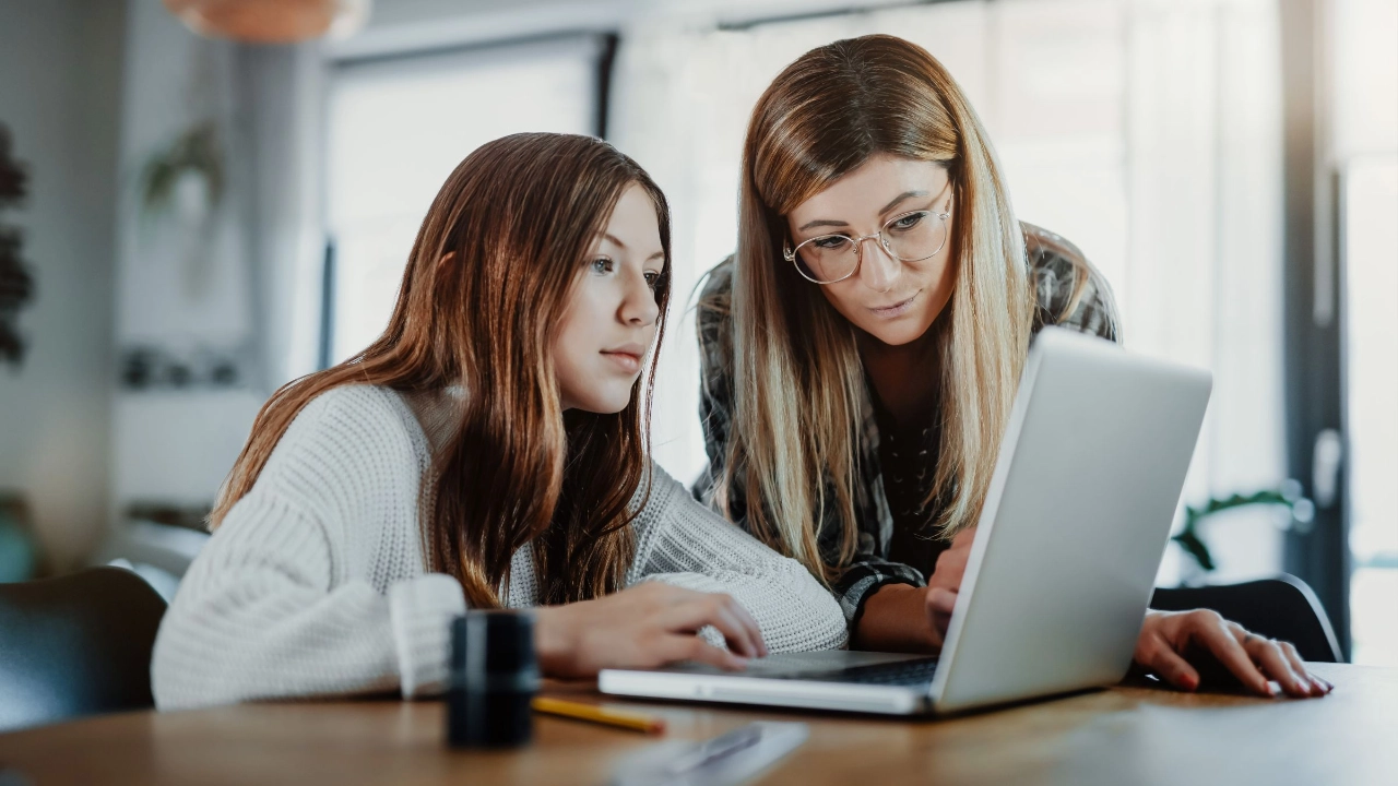 Mutter und Tochter schauen gemeinsam auf einen Laptop